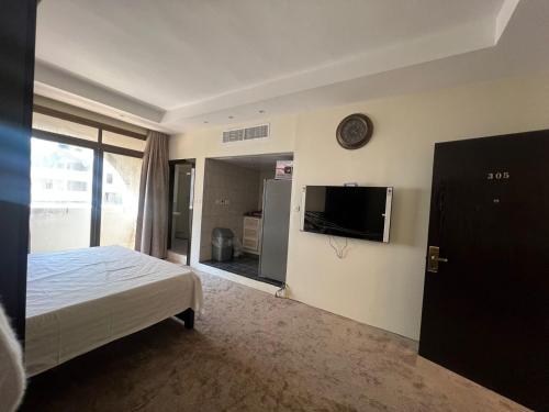 a bedroom with a bed and a flat screen tv at Limra complex in Abu Dhabi