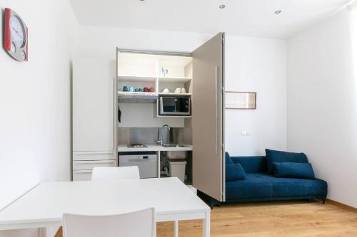 a living room with a blue couch and a kitchen at ~ Cozy Apartment ~ City Center [Train Station] in Trieste