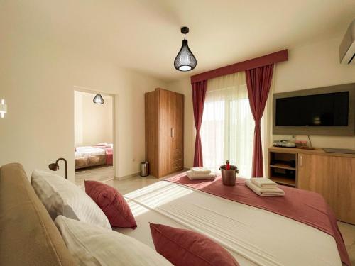 a bedroom with a large bed and a television at Apartments Ali in Ulcinj