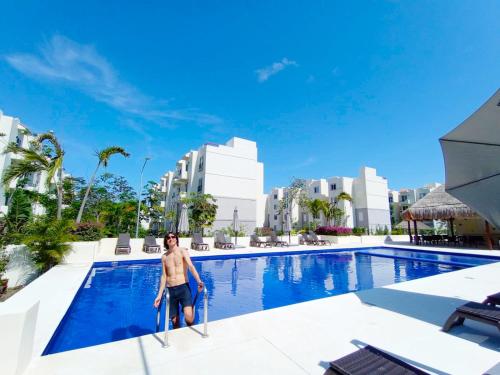 a man standing in the pool at a resort at Love Vacations Tulum in Tulum