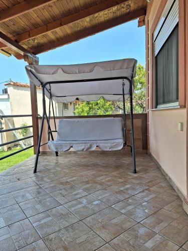a canopy bed on the porch of a house at Xristos Villa in Nea Vrasna