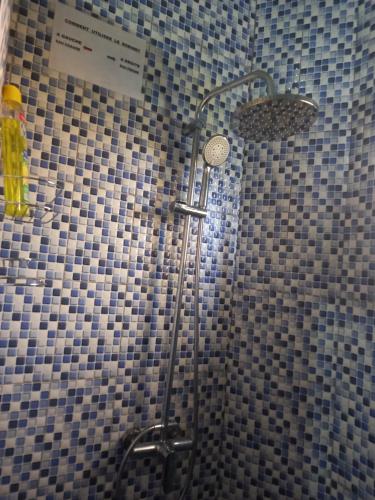 um chuveiro numa casa de banho com azulejos azuis e brancos em Villa meublée climatisée em Ziguinchor