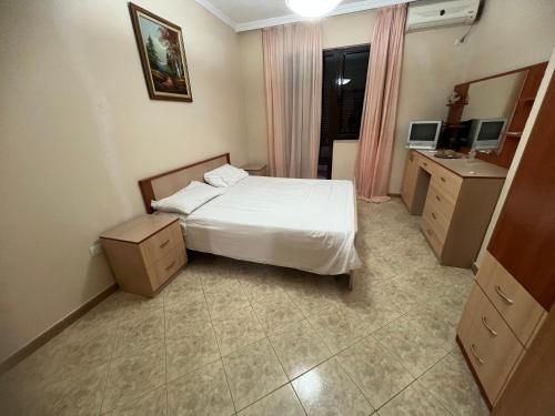 een slaapkamer met een bed, een wastafel en een spiegel bij Pallati Kajtazi in Durrës