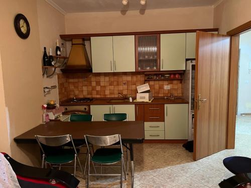 een keuken met een aanrecht en wat groene stoelen bij Pallati Kajtazi in Durrës