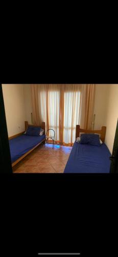 1 dormitorio con 2 camas y ventana en Costa cabo en Martil