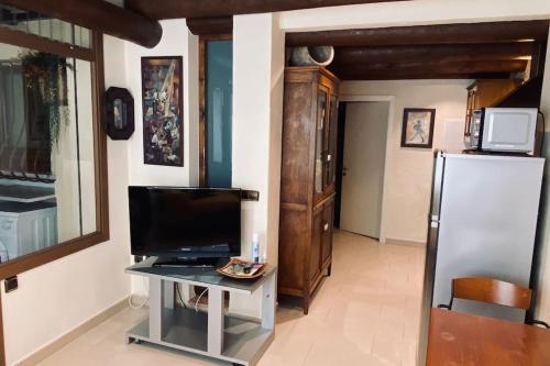 een woonkamer met een televisie en een koelkast bij El Niuet in L'Escala