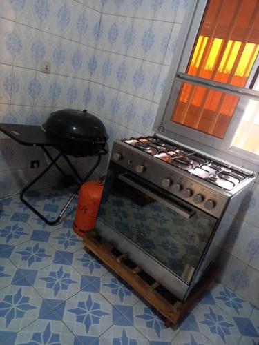 a stove in a kitchen with a pan on top of it at Villa meublée climatisée in Ziguinchor