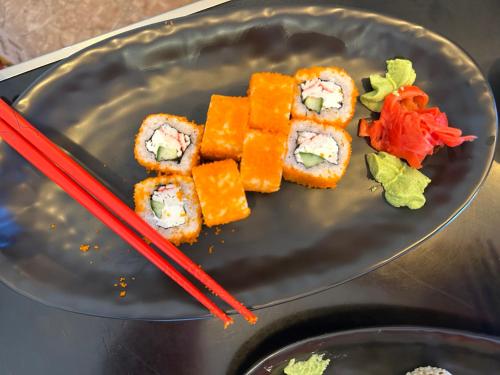 a plate with sushi and chopsticks on a table at Yolyans Hotel in Goris