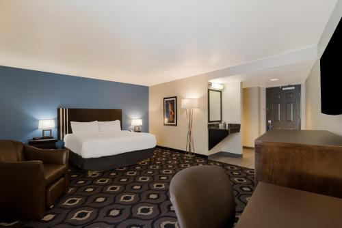 セントラルシティにあるGrand Z Hotel Casino by Red Lion Hotelsのベッドとデスクが備わるホテルルームです。