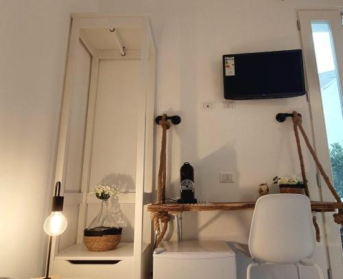 Zimmer mit einem Spiegel, einem Stuhl und einem TV in der Unterkunft Mirum Apuliae in Alberobello