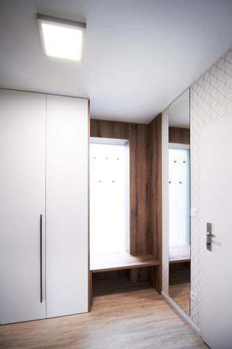 a dressing room with white cabinets and a mirror at Apartmány 316 a 317 Vila Zuberec in Zuberec