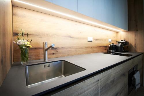 a kitchen counter with a sink and a vase of flowers at Apartmány 316 a 317 Vila Zuberec in Zuberec