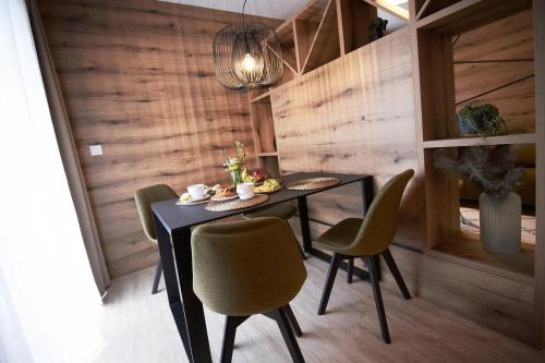 a dining room with a black table and green chairs at Apartmány 316 a 317 Vila Zuberec in Zuberec