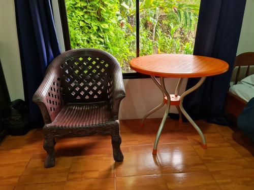 a table and a chair next to a table and a window at Osa Corcovado Lodge in Drake