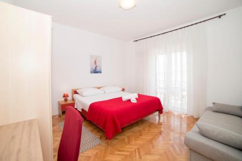 a white bedroom with a bed with a red blanket at Apartments Pavla&Niko in Lokva Rogoznica