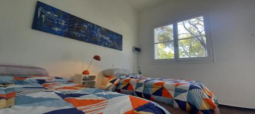 a bedroom with two beds and a window at Casa Candelina in Mendoza