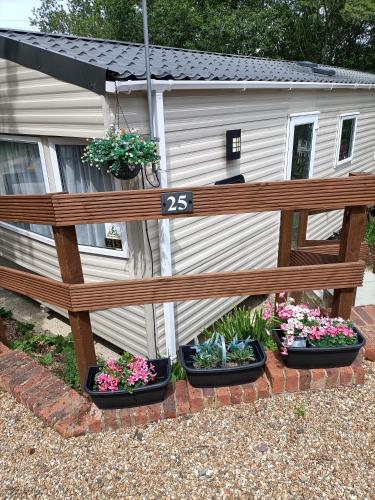 a wooden bench in front of a house with potted plants at Home from home in Hastings