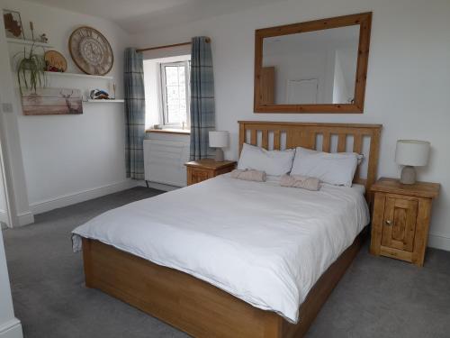 a bedroom with a large bed and a mirror at Converted Barn in Bath in Bath