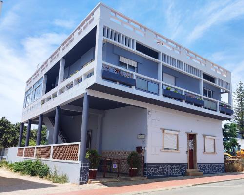 a white building with balconies on a street at Forever São Brás in São Brás de Alportel