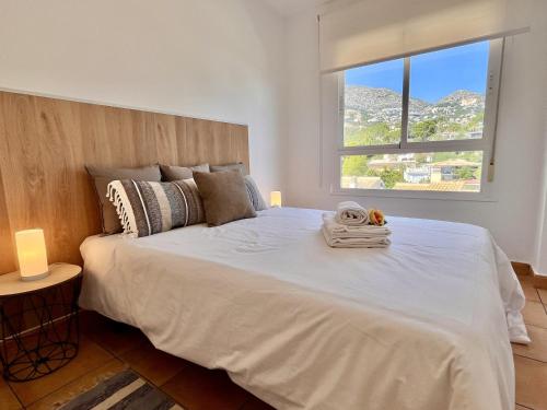 a bedroom with a large white bed with a window at Mar y Montana House by Gloove in Altea