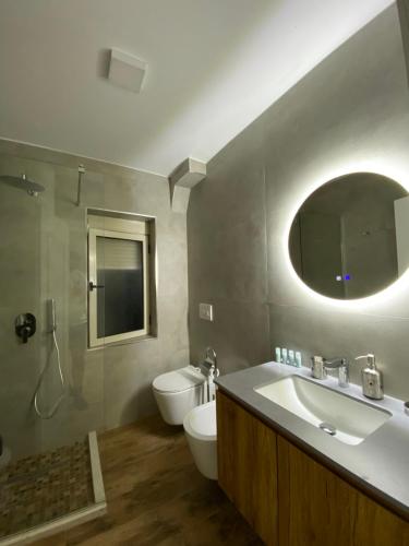 La salle de bains est pourvue d'un lavabo, de toilettes et d'un miroir. dans l'établissement Lucas Downtown, à Tirana
