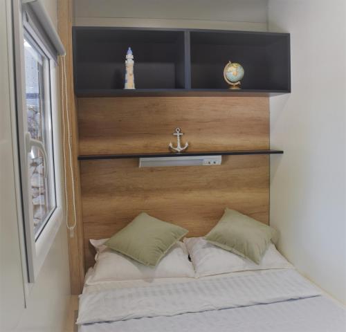 a bed with a wooden headboard in a room at FM mobile - Oaza mira, Drage in Drage