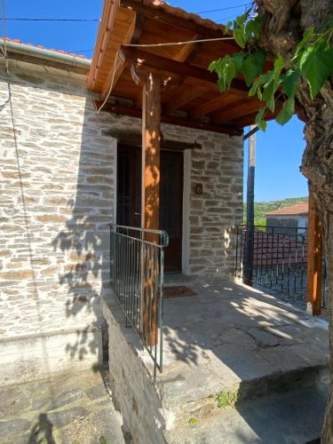 a stone house with a wooden pergola at Xinovrissi Studios in Xinóvrisi