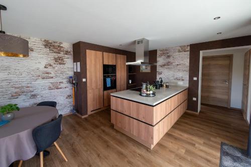 eine Küche mit Holzschränken und einem Tisch im Zimmer in der Unterkunft Gite Junior L'Ecrin du Ried PROCHE EUROPA-PARK in Artolsheim