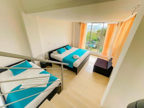 a small room with two beds and a window at HOTEL PANORAMA SOL in Chachagüí