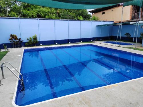 a large blue swimming pool next to a building at Apartamento una habitación in San Isidro de El General