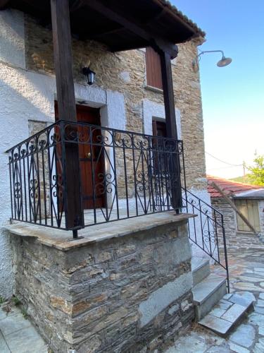 a stone building with a balcony with a door at Xinovrissi Studios in Xinóvrisi