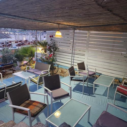 a group of chairs and tables on a patio at Amelie's Apartments & Beach Saranda in Sarandë