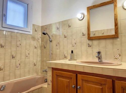 uma casa de banho com um lavatório, uma banheira e um espelho. em Villa sainte maxime golfe de Saint Tropez em Sainte-Maxime