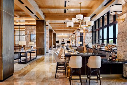 um bar num restaurante com bancos de bar em Omni PGA Resort Frisco-Dallas em Frisco