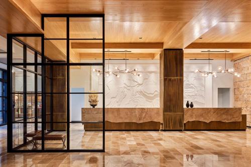 eine Lobby mit einer Treppe und einer Glaswand in der Unterkunft Omni PGA Resort Frisco-Dallas in Frisco