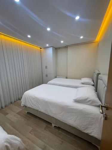 1 dormitorio con 2 camas y techo con luces. en شقه حديثه بمساحه كبيره 13 en Estambul