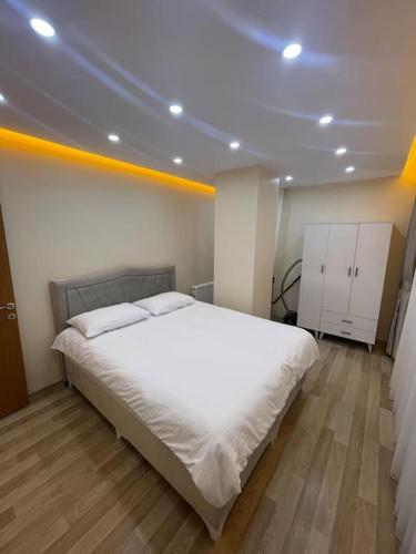 um quarto com uma cama grande e lençóis brancos em شقه حديثه بمساحه كبيره 13 em Istambul