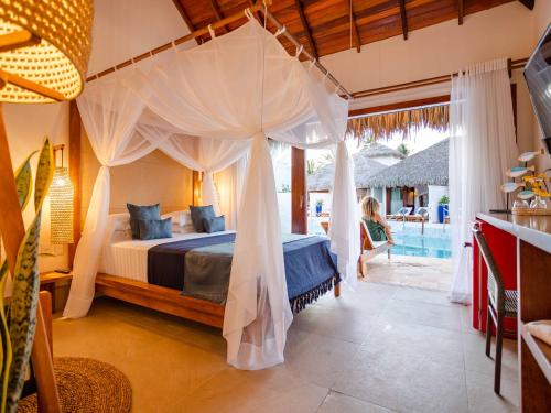 a bedroom with a canopy bed and a pool at MKNI Hotel - Ikaika Makani Experience in Prea