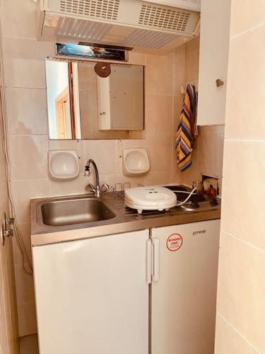 a small kitchen with a sink and a mirror at Sunset Sea View in Elíka