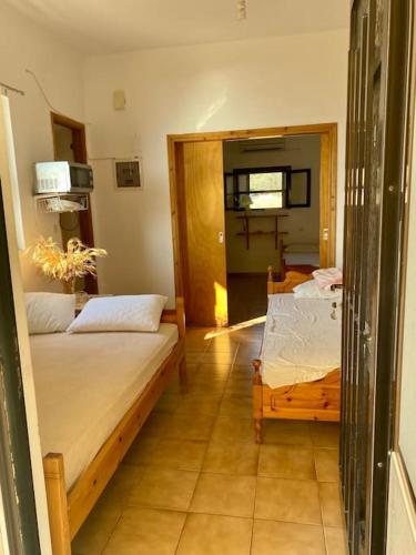 a room with two beds and a door to a bedroom at Sunset Sea View in Elíka