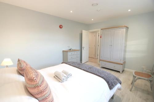 - une chambre avec un lit blanc et une chaise dans l'établissement Stylish apartment close to Causeway Coast & Glens, à Portglenone