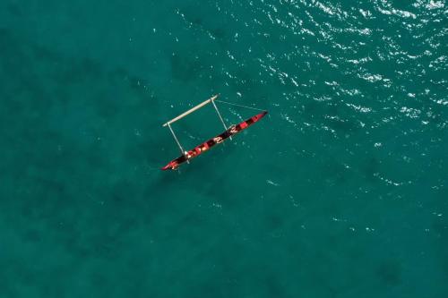 a boat in the middle of the water at Moana Surfrider, A Westin Resort & Spa, Waikiki Beach in Honolulu