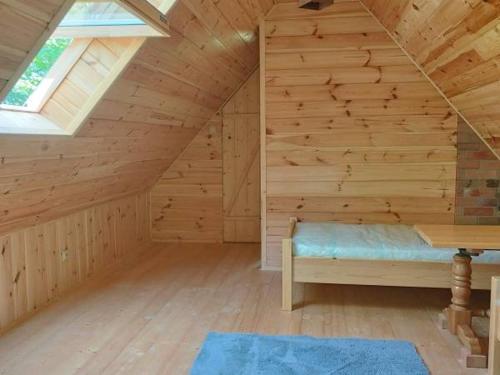 Cette chambre en bois mansardée comprend un banc. dans l'établissement Za Potokiem, à Grywałd