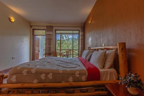 a bedroom with a wooden bed in a room with a window at Rushaga Gorilla Lodge in Bugambira