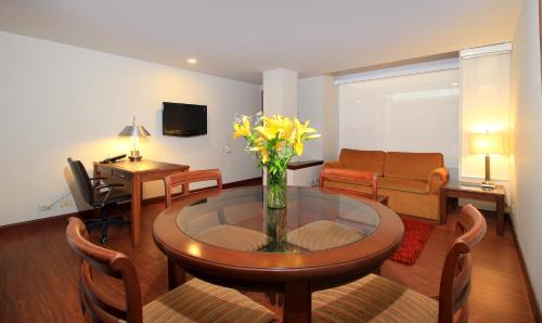 a living room with a vase of flowers on a table at Hotel Windsor House Inn By GEH Suites in Bogotá
