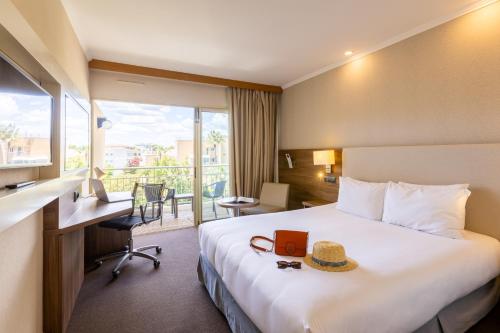 a hotel room with a bed with a hat on it at Luxotel Cannes in Cannes