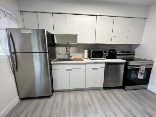 a kitchen with white cabinets and a stainless steel refrigerator at World Connect Miami in Miami