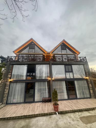 a house with large windows and a porch at Greenlife Dağevleri in Rize