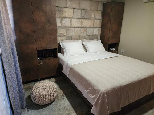 sypialnia z dużym łóżkiem i otomaną w obiekcie Hercegovina rooms w mieście Laktaši
