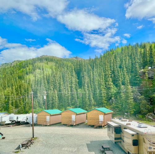 a row of huts in front of a mountain at Denali Rainbow Village RV Park and Motel in McKinley Park
